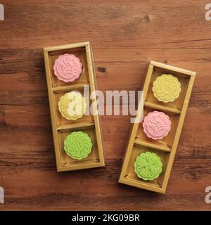 Traditional Chinese Mid Autumn Festival Food, Colorful Rice Cakes Snowskin Mooncakes with Variety of Fillings on Simple Gold Packaging Stock Photo
