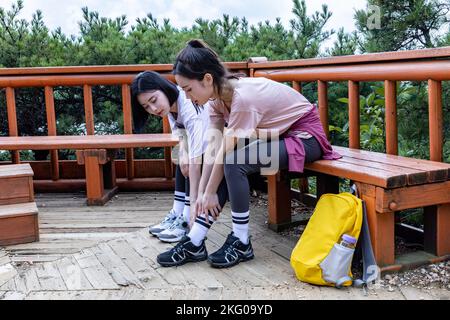 korean young women hiking and plogging worried about ankle pain Stock Photo