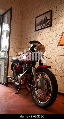 a restored old retro motorcycle kept on display in a coffee shop for attracting customers and enthusiasts. Stock Photo