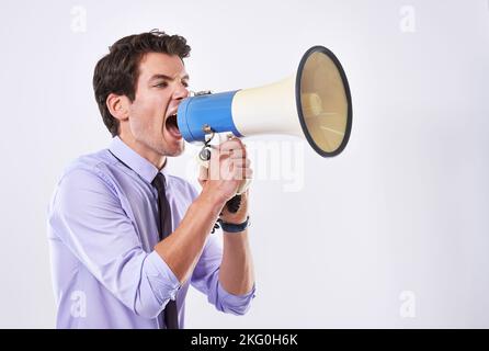 Share your business with the world. Cropped studio shot of a businessman against a white background shouting a message through a megaphone. Stock Photo