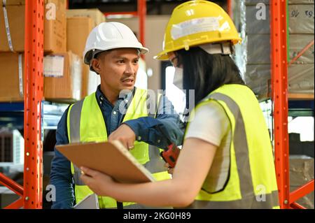 Angry and mad Asian male warehouse supervisor complained to his female worker while inspecting the warehouse. factory and shipping business concept Stock Photo