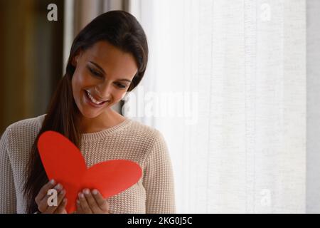 Heart, love and woman reading card for valentines celebration, mothers day or celebrate special day. Happy, smile and young excited person read red Stock Photo