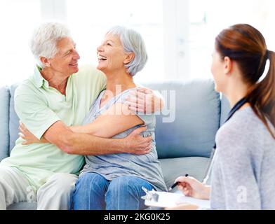 At last I can relax. A doctor explaining positive test results to an overjoyed senior patient and her husband. Stock Photo