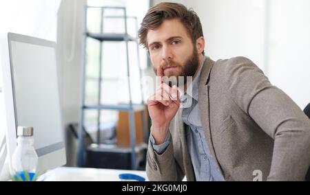 Considering the corporate solution. Portrait of a handsome creative professional looking thoughtfully at the camera. Stock Photo