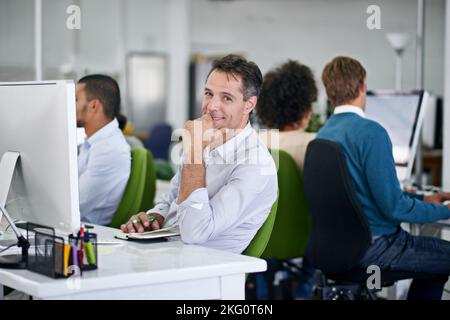 Im at the top of my game. a group of creative businesspeople working on computers in the office. Stock Photo