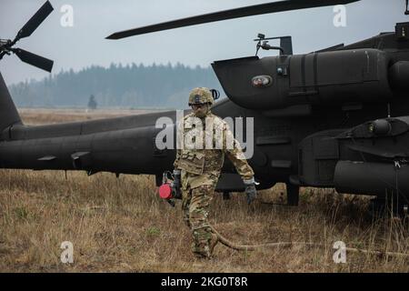 Soldiers assigned to 1-229 Attack Battalion, 16th Combat Aviation Brigade refuel, rearm, and repair AH-64E Apache attack helicopters and other vehicles at the Forward Arming and Refueling Point on Joint Base Lewis-McChord, Wash., Oct. 20, 2022. Stock Photo