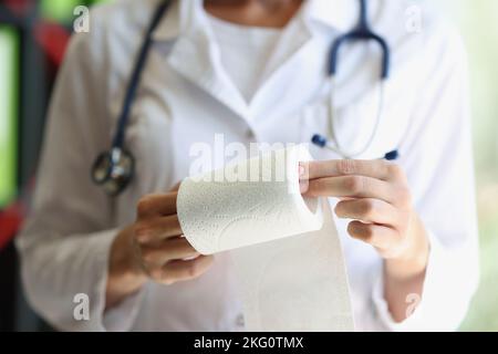 Female doctor hands demonstrates toilet paper roll Stock Photo