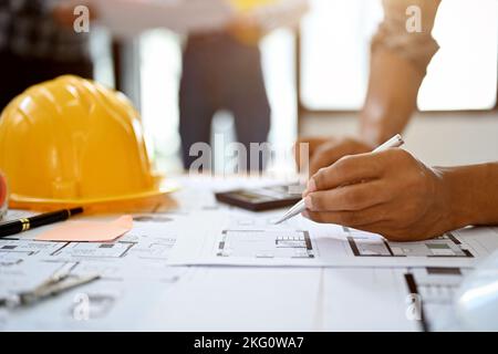 close-up hands image, Professional Asian male construction engineer or worker holding pen, working on blueprint. Stock Photo