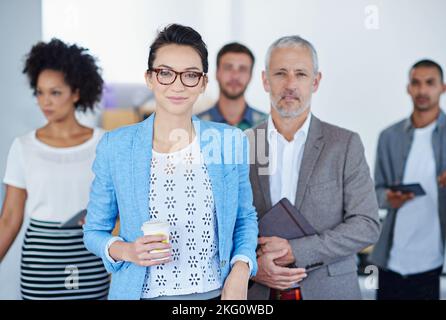 Diverse professionals. Portrait of a diverse group of businesspeople standing in an office. Stock Photo