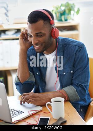 This playlist is awesome. A handsome casually dressed businessman working in his office. Stock Photo