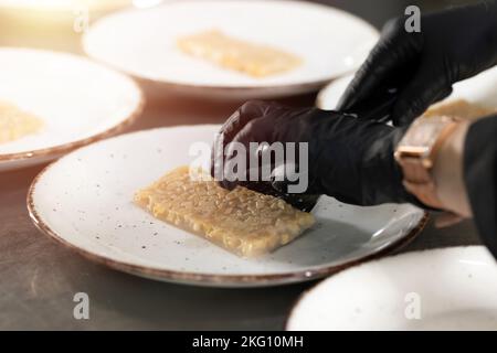 Hand serving a cut of quince jelly in restaurant counter Stock Photo