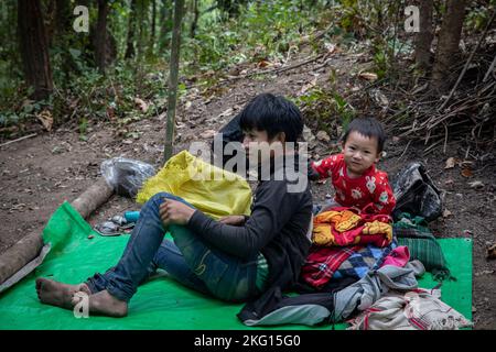 An internally displaced family recently arrives to safety after a five-day walk in a forested area close to the border of Thailand, Myanmar, Asia. Stock Photo