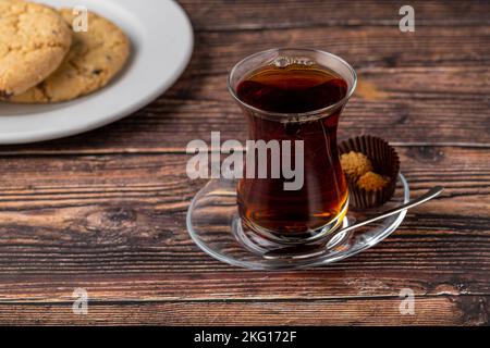 Freshly brewed black Turkish tea with cookies on wooden table Stock Photo