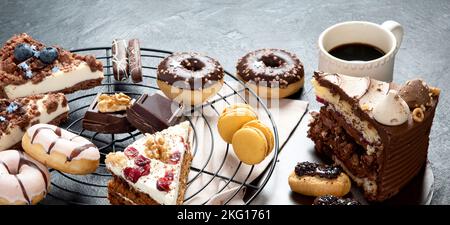 Table with various cookies, donuts, cakes, cheesecakes on dark background.  Delicious dessert table. Top view, flat lay Stock Photo