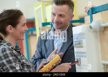 a happy female electrician using multimeter Stock Photo
