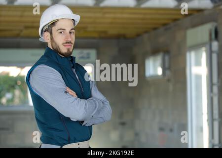 engineer in white hardhat standing on construction site Stock Photo