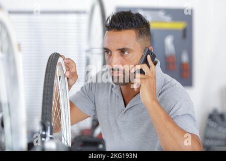 bearded man with bike using his phone Stock Photo