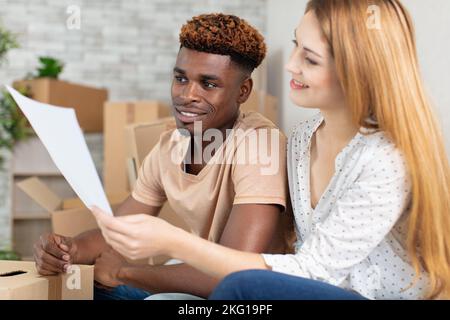 happy mixed young couple calculate domestic bills mortgage rate Stock Photo