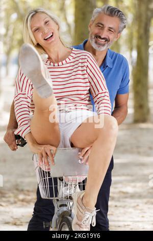 playful mature couple with bikes outdoors Stock Photo