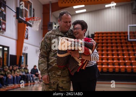 Master Sgt. Earl Plumlee, Medal of Honor recipient, receives a blanket from his former teacher at Merritt High School in Merritt, Oklahoma, Oct. 21, 2022. Plumlee, a native Oklahoman, toured his home state Oct. 18-22. During his visit, Plumlee spoke at a Merritt High School football pep rally about his experiences being a Medal of Honor recipient and what it meant to be back home. (Oklahoma National Guard photo by Sgt. Reece Heck) Stock Photo