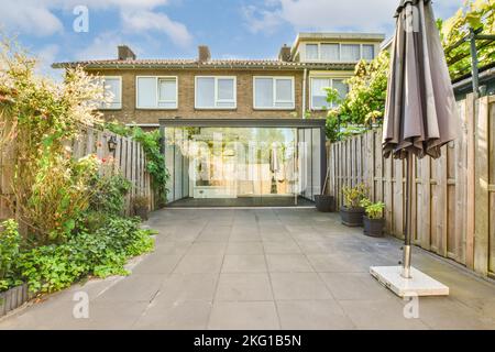 Simple small patio with small garden near wooden fence Stock Photo