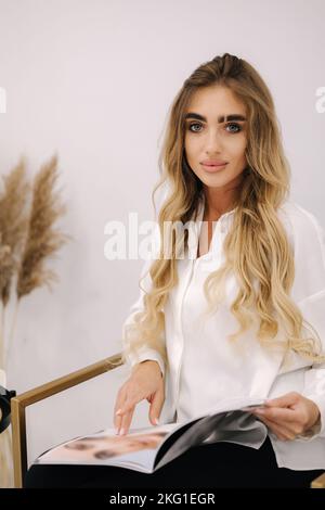 Pretty woman look magazine while waiting. Beauty studio Stock Photo