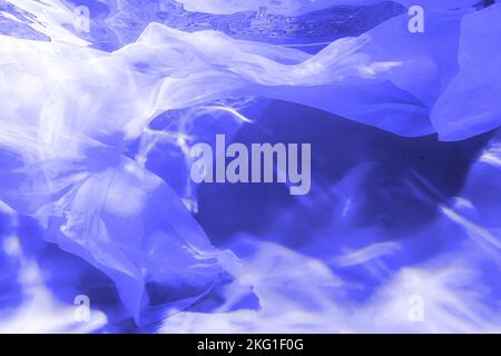 Fabric in soft focus abstract and blurred ripped water with waves and with defocused bright sun light in the swimming pool . Banner. Toned in color of the year 2022, very peri. Stock Photo