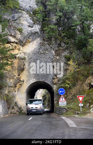 White Van Exits Narrow Single File Road Tunnel through Cliffs or Rock Outcrops of the Verdon Gorge Rougon Alpes-de-Haute-Provence France Stock Photo