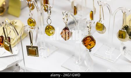 Earrings with natural amber are on the counter, close up photo with selective soft focus Stock Photo