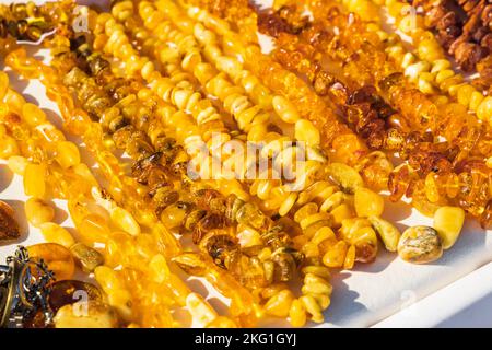 Amber beads lay on the counter on a sunny day Stock Photo