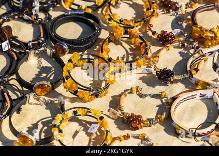 Assortment of amber bracelets laying on the counter on a sunny day Stock Photo