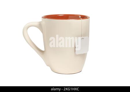 Beige ceramic mug with teabag label. isolated on white background Stock Photo
