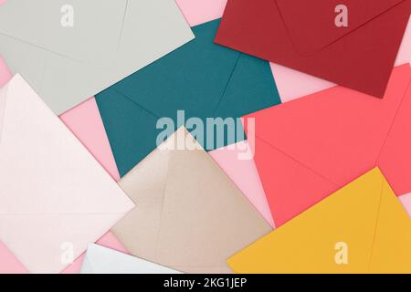 Multicolored envelopes scattered on a pink background. Creative background. Stock Photo