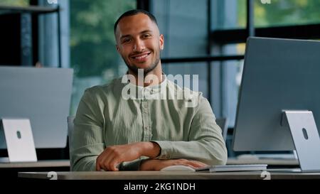 Happy smiling male investor multiracial worker developer programmer creative designer guy African American man with computer in office looking at Stock Photo
