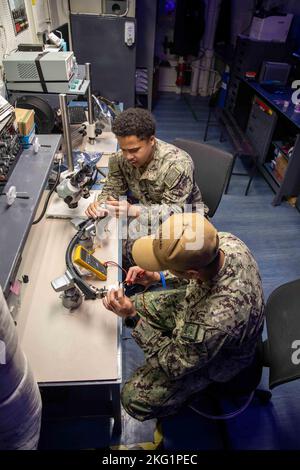 221024-N-IV962-1022 SAN DIEGO (Oct. 24, 2022) – Aviation Electronics Technician 3rd Classes Jervin Manalastas, left, and Kendrick Oliver test the frequency in a computer automated support system (CASS) cable aboard amphibious assault ship USS Makin Island (LHD 8), Oct. 24. CASS cables are used to test and check MV-22s before a flight. Makin Island is a Wasp-class amphibious assault ship homeported in San Diego. AIMD,Aviation Electronics Technician,LHD 8,MKI,Sailor, Stock Photo