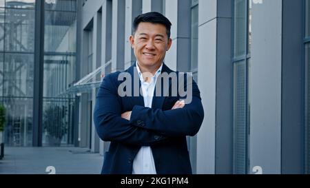 Smiling happy confident motivated successful 40s middle-aged Asian Korean man entrepreneur employer company CEO realtor businessman boss leader posing Stock Photo