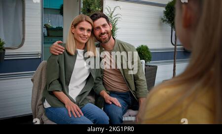 Hugging parents mother and father listening unrecognizable child girl kid daughter tell poem singing song standing back view baby talk speak talking Stock Photo