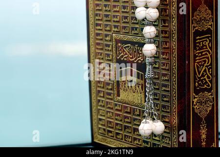 Front of the Quran in Arabic and muslim prayer beads. Islam symbols. Stock Photo