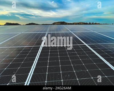A top view of solar panels under bright blue cloudy sky Stock Photo