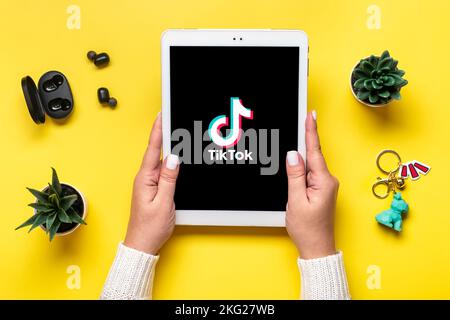 Bangkok, Thailand. October 2022 Tablet Tik Tok application icon, logo on screen and wireless headphones on colorful background Trendy social media net Stock Photo