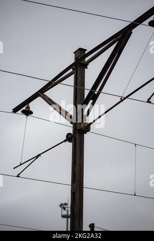 A vertical grayscale of an electrical insulator on an electricity pole Stock Photo