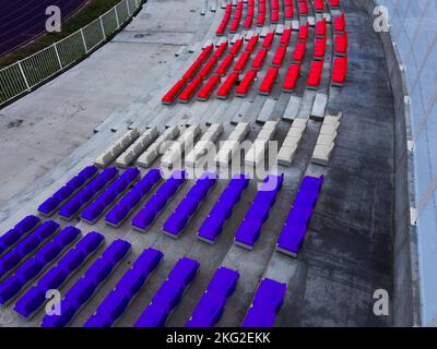 Seats of a football stadium colored in different team colors Stock Photo