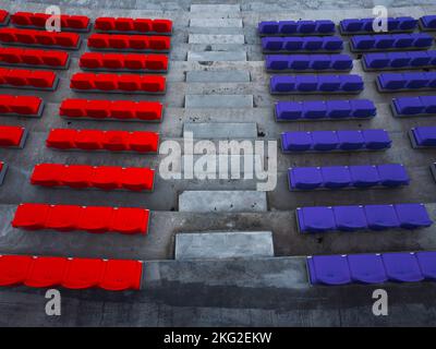 Seats of a football stadium in different colors. Red VS blue. Stock Photo