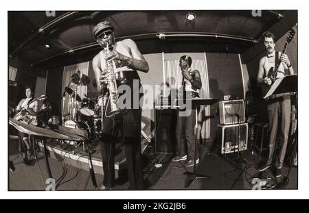 A 1986 fisheye lens photo of jazz saxophonist Julius Hemphill playing his soprano saxophone at a showcase for industry people. In a Manhattan studio. With bill Frisell on guitar. Stock Photo