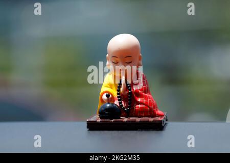 Buddhist monk figurine  in a car. Ho Chi Monh city. Vietnam. Stock Photo