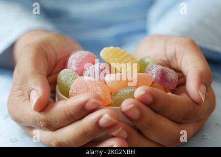 women holding a bowl of gummy colorful candies  Stock Photo