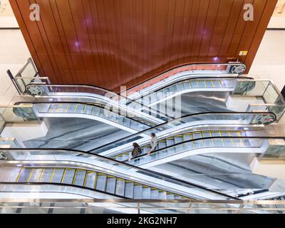 Commuters using the escalator to their next destionation in the underground train in Singapore. Stock Photo