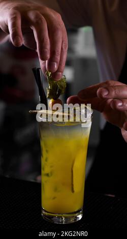 A vertical shot of a person preparing fresh pineapple cocktail on an isolated background Stock Photo
