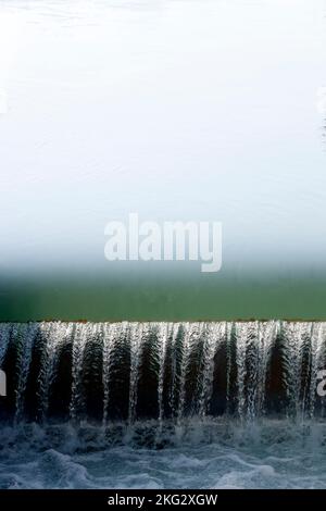 Small water fall reflecting  green color.  France. Stock Photo