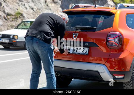 Serbia-Kosovo border crossing. Driver complying with number plate regulations. Stock Photo